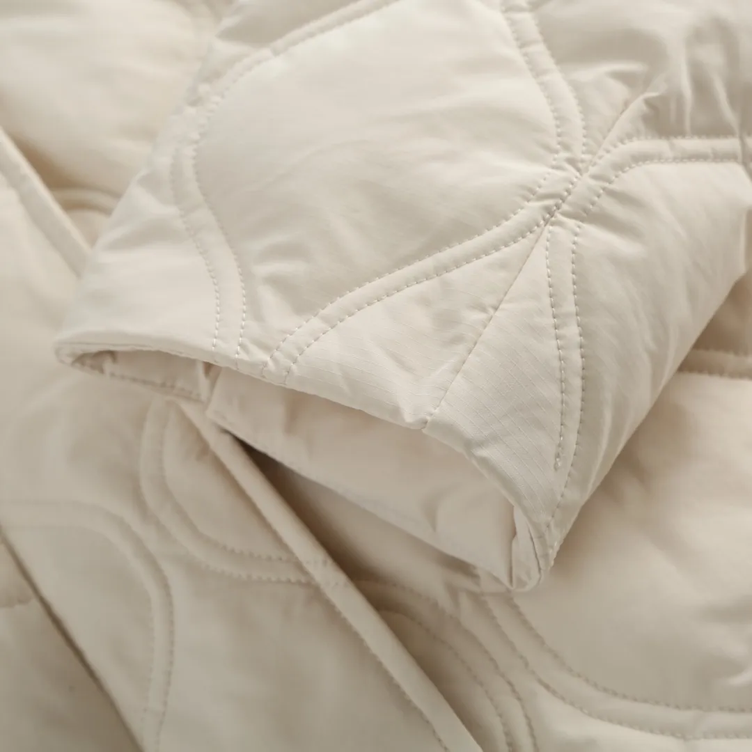 P1060 Canada Goose hooded down jacket fabric selection; nylon fabric is known for its high strength, excellent wear and tear resistance, and excellent durability. At the same time, it is light in texture, easy to move, and has excellent water-repellent function, which can effectively deal with light rain and humidity. Technology: Double-needle quilting technology is used. Double-needle quilting technology is a sophisticated sewing technology. Its core feature is to use two needles to quilt at the same time to form two parallel stitches. This design not only makes the quilting lines visually more three-dimensional, regular and refined, but more importantly, it greatly enhances the firmness of the sewing. The double lines in parallel form a more stable structure, which can effectively lock the internal filling and significantly prevent it from shifting, accumulating or velveting during wearing or washing, thereby ensuring that the thermal insulation layer is evenly distributed without cold spots, and comprehensively improves the durability and thermal efficiency of the product.    High-quality filling: It is filled with 90% selected white duck down, weighing 170g, ensuring fluffy rebound, lightness and warmth.  Accessories: one-to-one customized three-standard, one-to-one customized zipper, one-to-one customized hardware